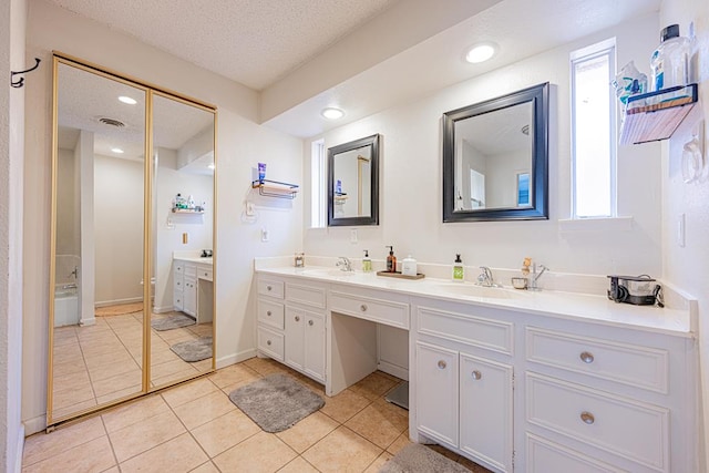 bathroom featuring vanity, tile patterned floors, and a textured ceiling