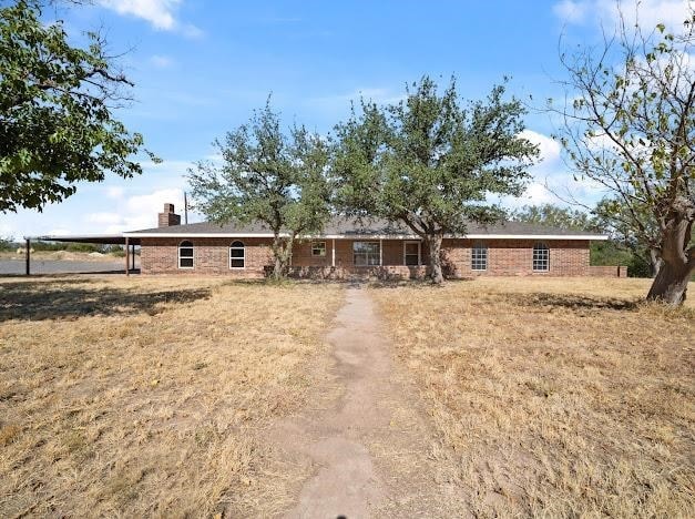 single story home with a carport and a front lawn