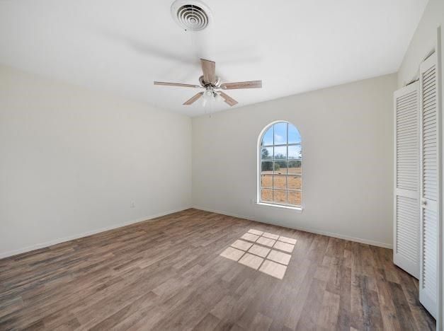 unfurnished bedroom with a closet, ceiling fan, and dark wood-type flooring