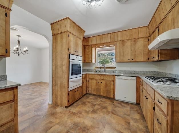 kitchen featuring a notable chandelier, sink, white appliances, and hanging light fixtures