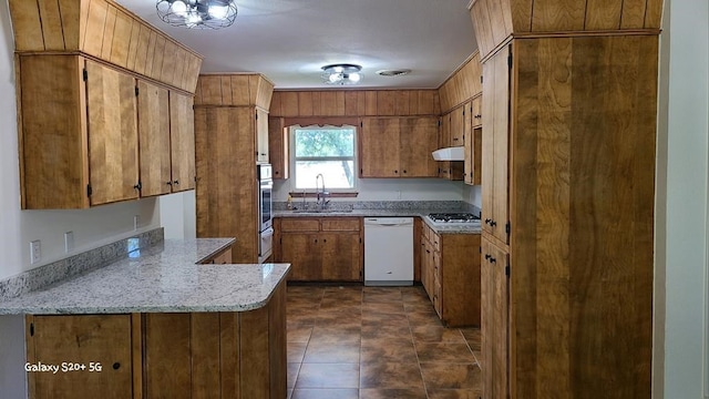 kitchen featuring sink, light stone counters, range hood, kitchen peninsula, and appliances with stainless steel finishes