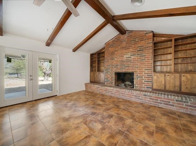 unfurnished living room featuring french doors, a brick fireplace, built in shelves, ceiling fan, and lofted ceiling with beams