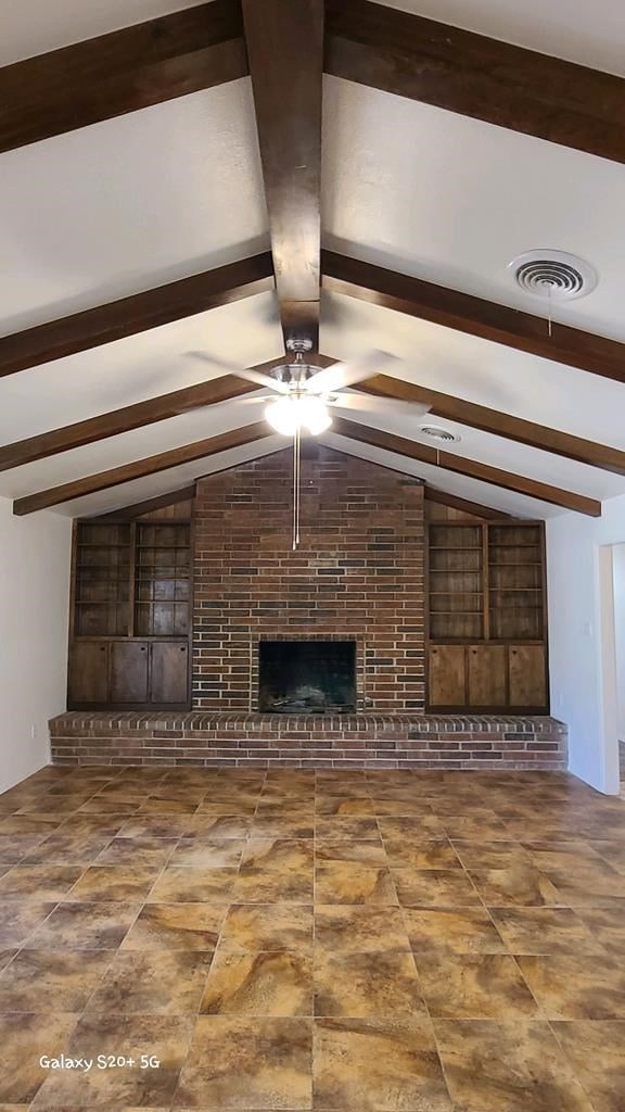 unfurnished living room featuring lofted ceiling with beams, ceiling fan, and a fireplace