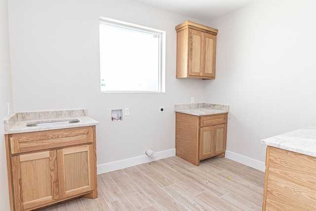 bathroom with wood finished floors, a sink, baseboards, and two vanities