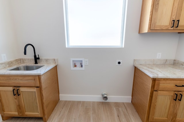 2209 S County Rd 1059, Midland, TX 79706 - laundry room featuring washer hookup, electric dryer hookup, light wood-type flooring, cabinet space, and baseboards