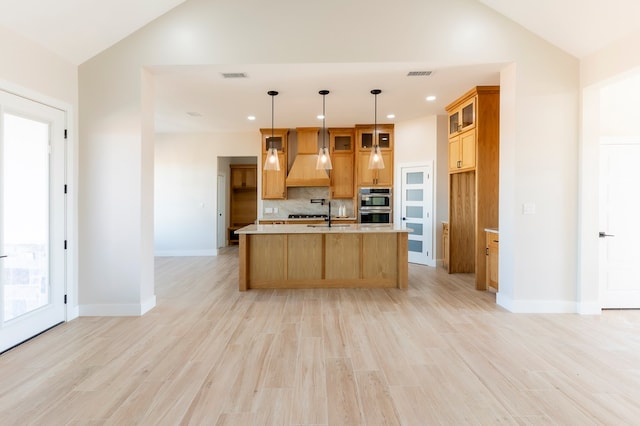 2209 S County Rd 1059, Midland, TX 79706 - kitchen featuring double oven, decorative backsplash, light countertops, glass insert cabinets, and light wood-type flooring
