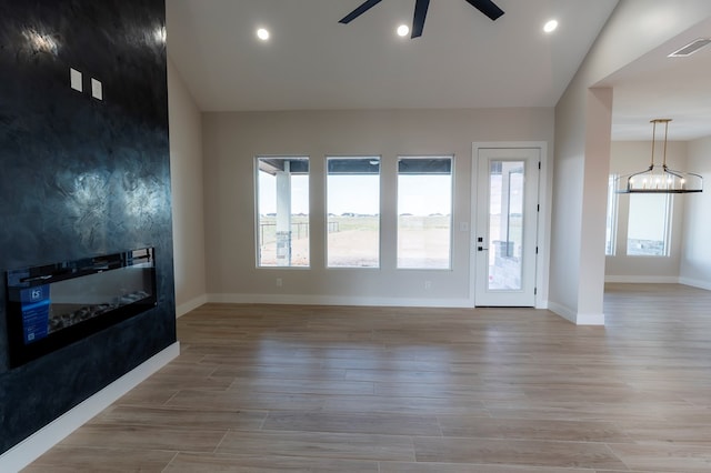 2209 S County Rd 1059, Midland, TX 79706 - unfurnished living room with ceiling fan, baseboards, recessed lighting, light wood finished floors, and a chandelier