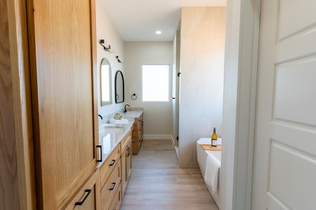2209 S County Rd 1059, Midland, TX 79706 - full bathroom featuring a stall shower, a bathtub, double vanity, wood finished floors, and baseboards