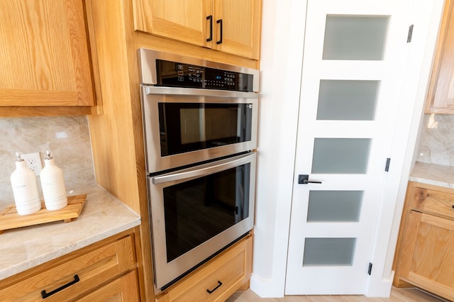2209 S County Rd 1059, Midland, TX 79706 - kitchen featuring double oven, backsplash, light stone countertops, and light brown cabinets