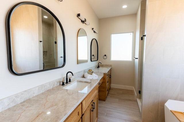 2209 S County Rd 1059, Midland, TX 79706 - bathroom with a stall shower, double vanity, baseboards, recessed lighting, and wood finished floors
