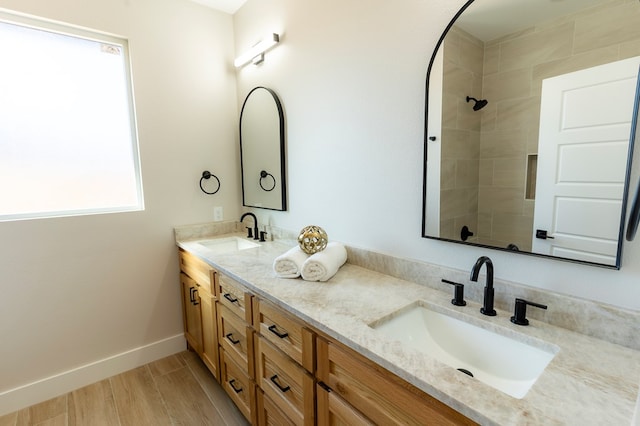 2209 S County Rd 1059, Midland, TX 79706 - full bathroom featuring double vanity, tiled shower, wood finished floors, and baseboards