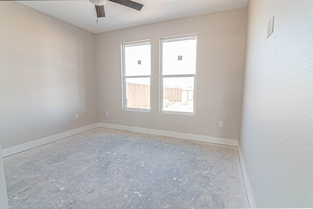empty room with baseboards, ceiling fan, and a healthy amount of sunlight