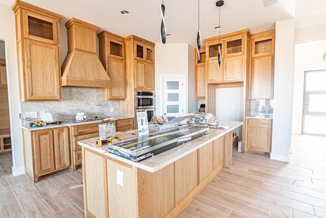 kitchen featuring light countertops, light wood finished floors, and double oven