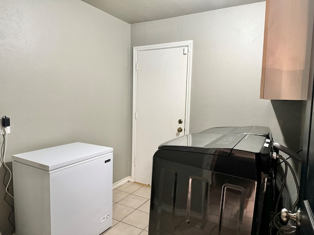 clothes washing area with light tile patterned floors and washing machine and clothes dryer