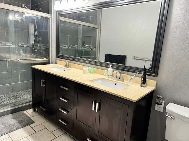 bathroom with tile patterned flooring, toilet, walk in shower, and vanity