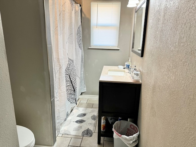 bathroom featuring toilet, vanity, a shower with curtain, and tile patterned flooring