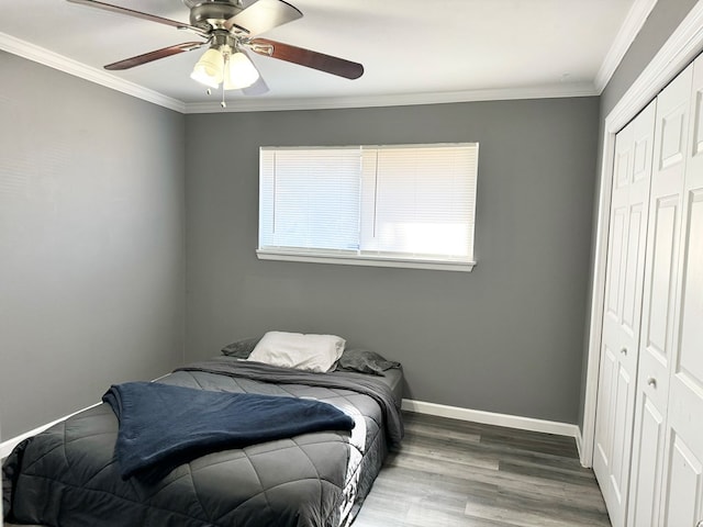 bedroom featuring ceiling fan, a closet, hardwood / wood-style floors, and crown molding