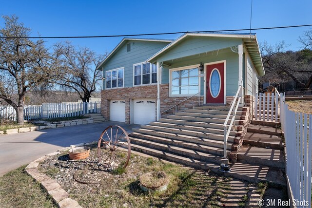 2185 Hillside, San Angelo, TX 76904 - view of front facade with driveway, an attached garage, fence, and stone siding