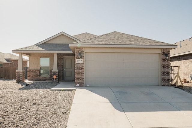 view of front of house with brick siding, an attached garage, concrete driveway, and a shingled roof