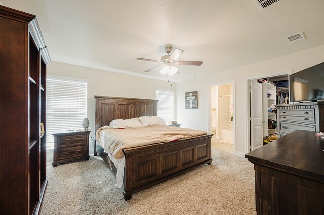 bedroom with visible vents, a ceiling fan, connected bathroom, and a spacious closet