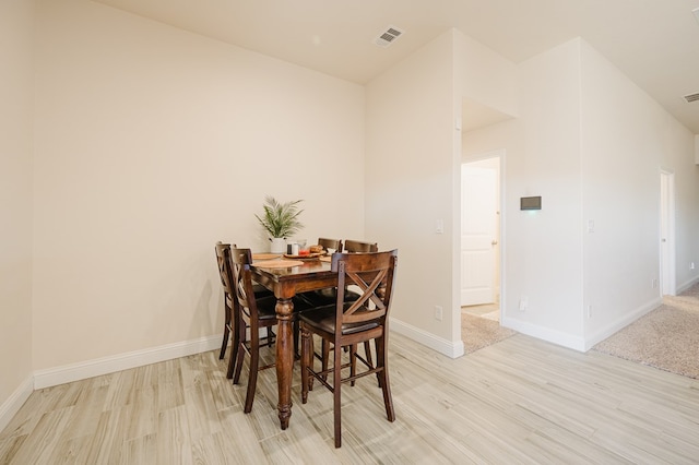 dining space with light wood-type flooring, baseboards, and visible vents