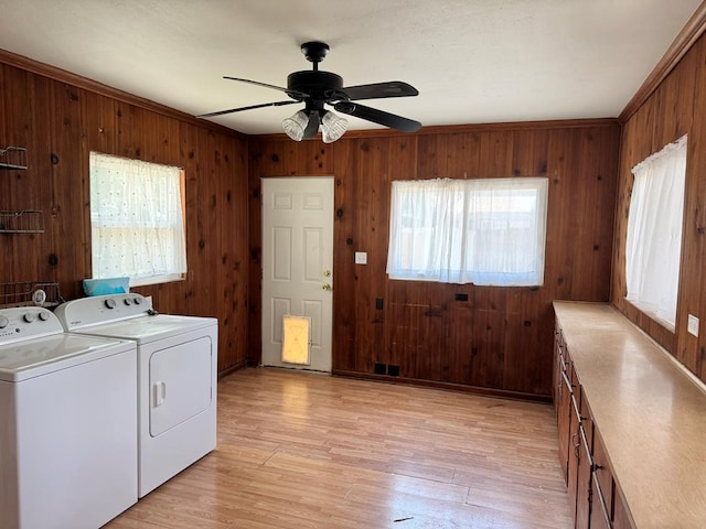 1207 W Tennessee Ave, Midland, TX 79701 - laundry room with washing machine and dryer, cabinet space, ceiling fan, wood walls, and light wood-style flooring