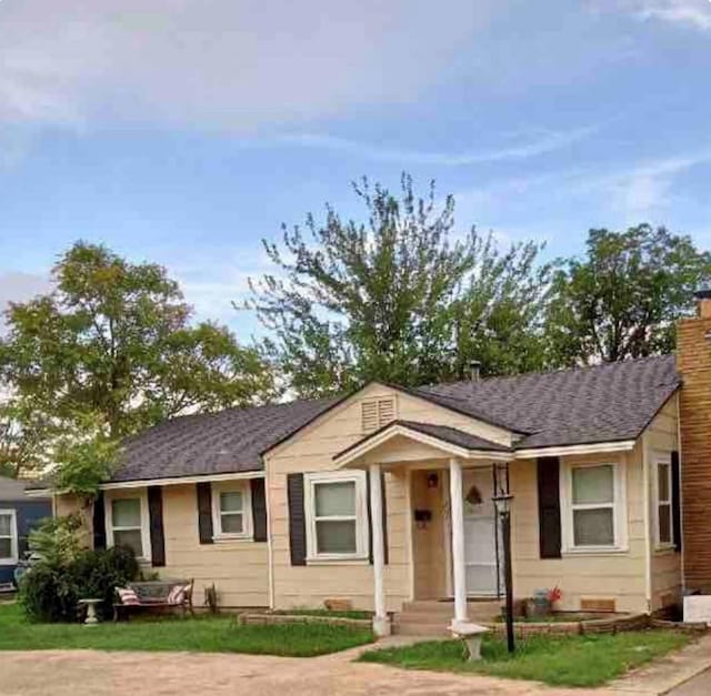 view of front of property featuring a chimney and a shingled roof