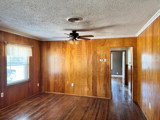 1207 W Tennessee Ave, Midland, TX 79701 - empty room featuring wood finished floors, a textured ceiling, ceiling fan, wooden walls, and ornamental molding