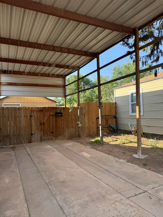 view of patio / terrace with a gate, fence, and a carport