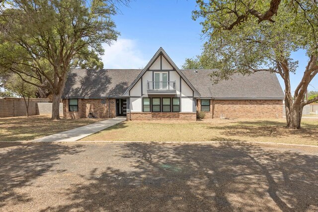 6009 Briarwood Ave, Odessa, TX 79762 - tudor home with a shingled roof, brick siding, stucco siding, and fence