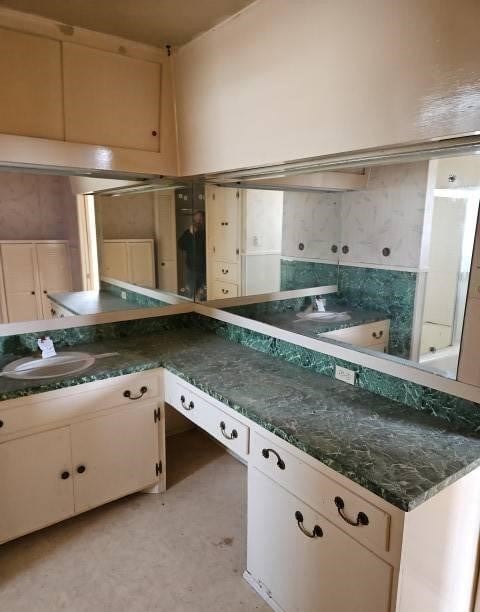 kitchen with dark countertops, white cabinets, and a sink