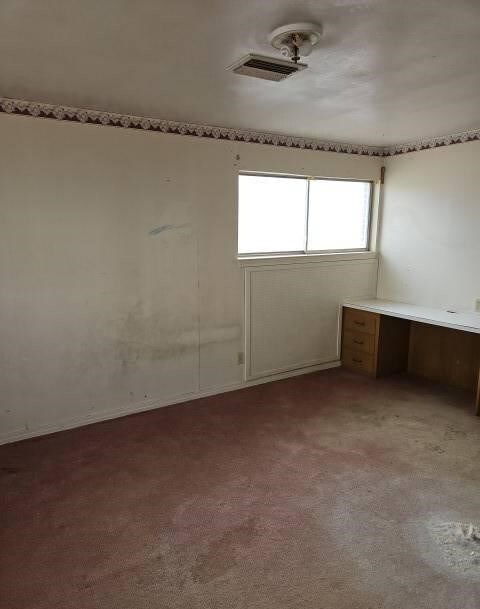 spare room with visible vents and light colored carpet