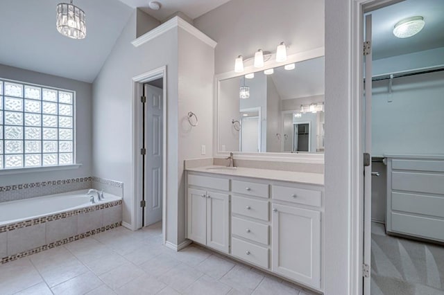 5706 Devlin Pl, Midland, TX 79707 - bathroom featuring vaulted ceiling, vanity, a garden tub, tile patterned floors, and a walk in closet