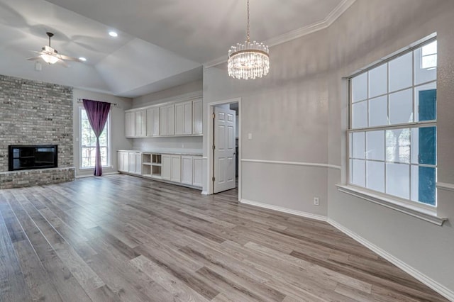 5706 Devlin Pl, Midland, TX 79707 - unfurnished living room with ceiling fan, light wood finished floors, a chandelier, baseboards, and lofted ceiling