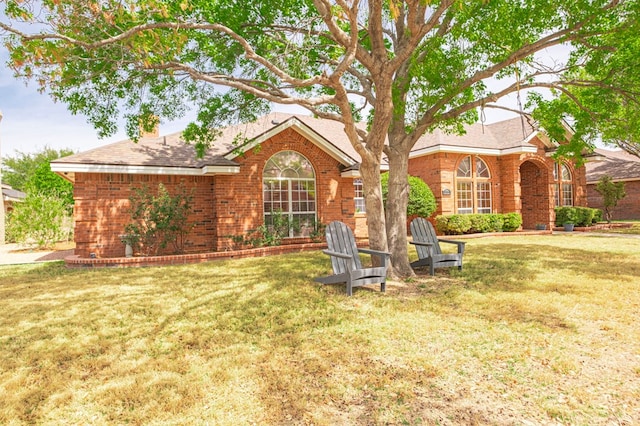 5706 Devlin Pl, Midland, TX 79707 - view of front facade featuring a front yard, brick siding, and a shingled roof