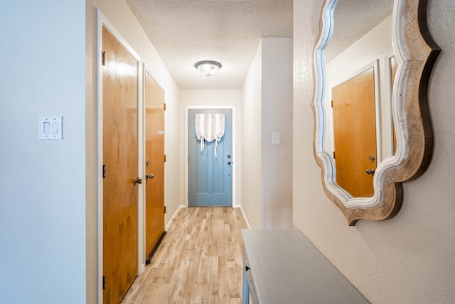4906 San Antonio Ave, Midland, TX 79707 - doorway with light wood-style flooring, a textured ceiling, and baseboards