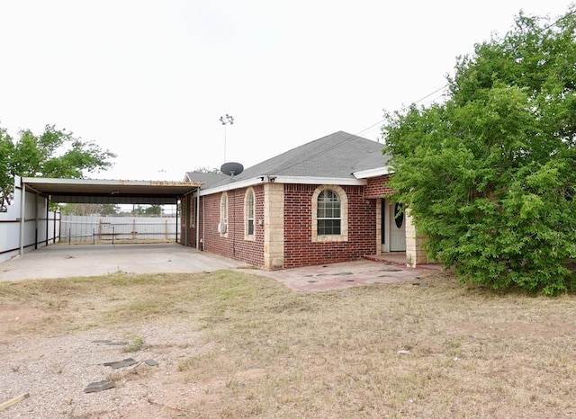 back of property featuring fence and a carport