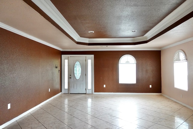 entrance foyer with ornamental molding, a tray ceiling, baseboards, a textured ceiling, and light tile patterned floors