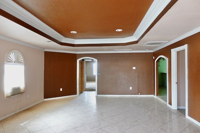 unfurnished room with arched walkways, ornamental molding, a raised ceiling, baseboards, and recessed lighting