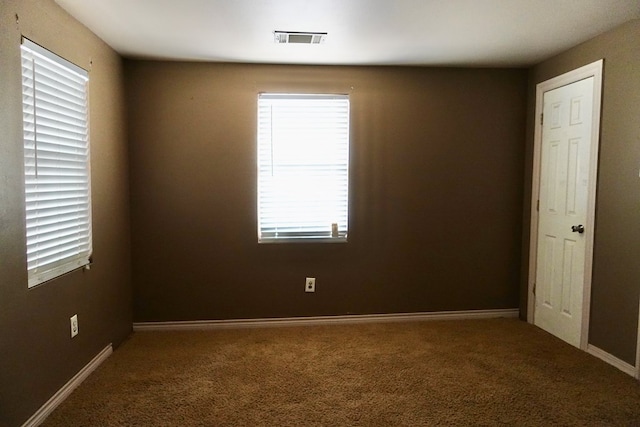 empty room featuring carpet flooring, plenty of natural light, and baseboards
