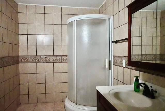 bathroom featuring tile walls, a stall shower, and vanity