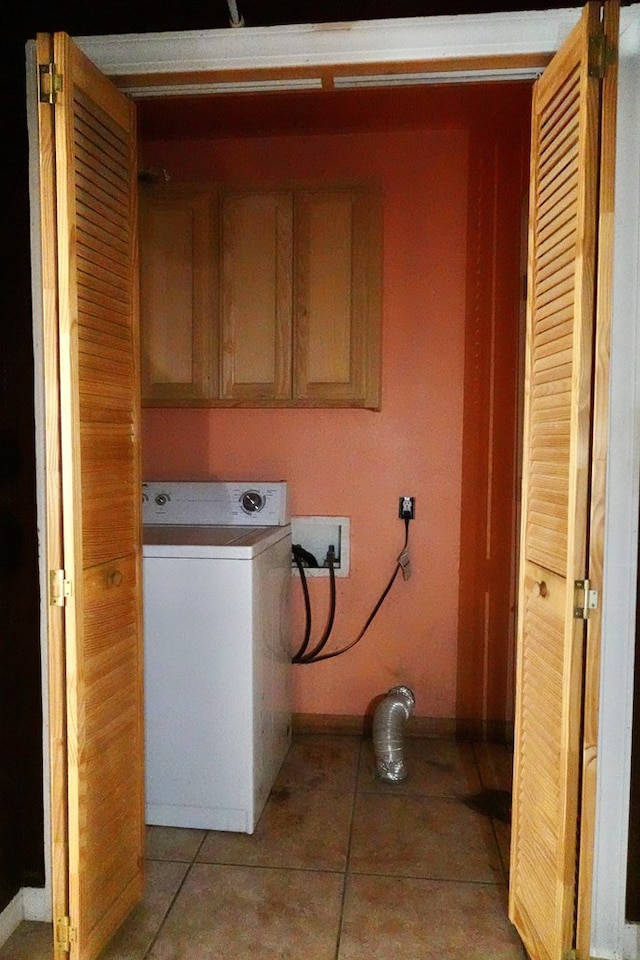 washroom featuring washer / clothes dryer, baseboards, cabinet space, and light tile patterned floors