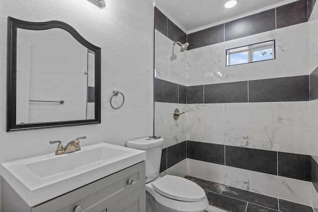 201 E Pine Ave, Midland, TX 79705 - bathroom featuring toilet, a tile shower, vanity, and a textured wall