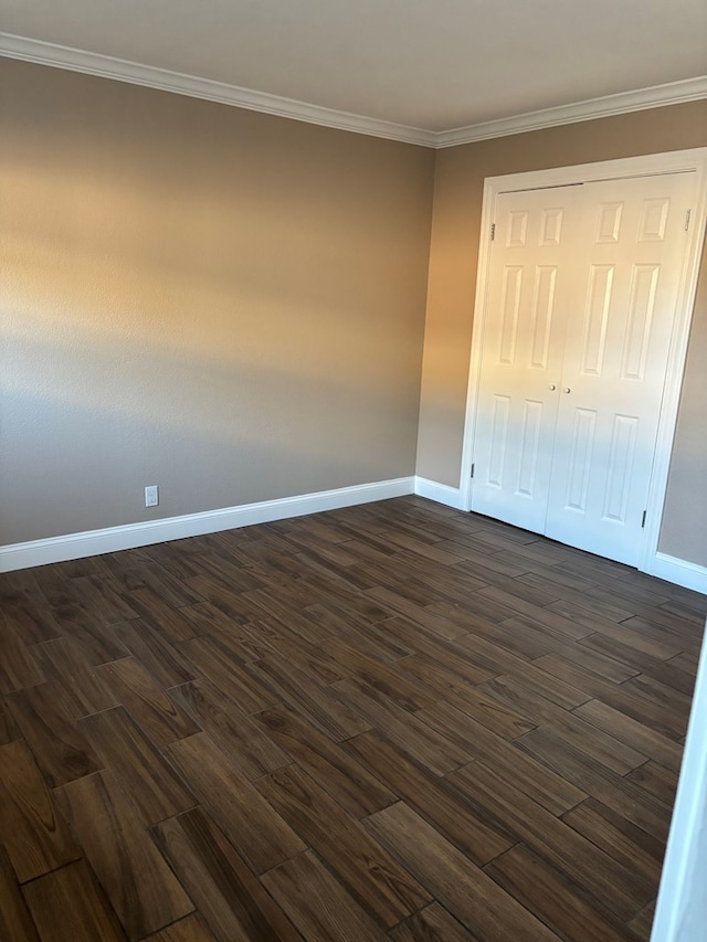 unfurnished bedroom featuring dark hardwood / wood-style flooring, a closet, and crown molding