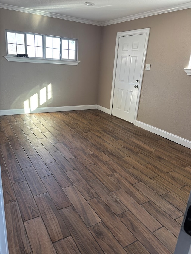 spare room with dark hardwood / wood-style flooring and crown molding