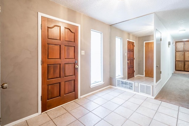 entrance foyer with light tile patterned floors and a textured ceiling