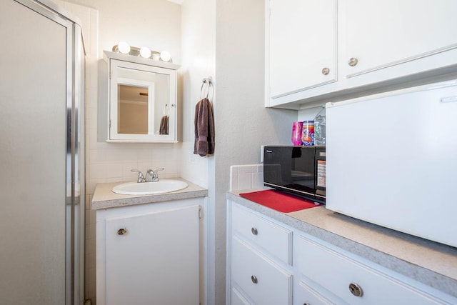 bathroom with vanity and tasteful backsplash