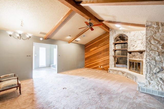 unfurnished living room with ceiling fan with notable chandelier, vaulted ceiling with beams, a textured ceiling, a fireplace, and carpet floors