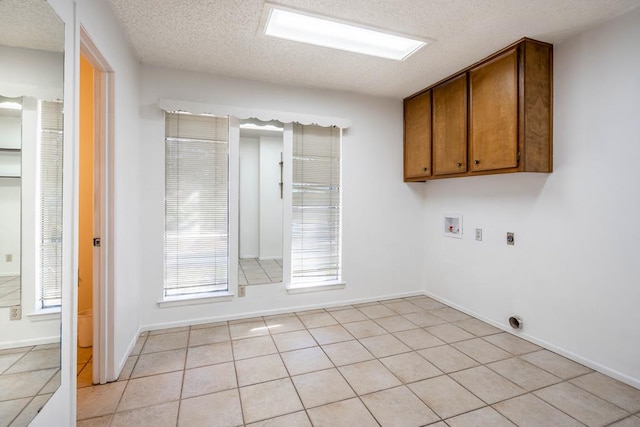 washroom featuring washer hookup, a textured ceiling, light tile patterned floors, and electric dryer hookup