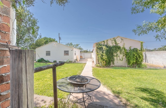 view of yard featuring an outbuilding and an outdoor fire pit